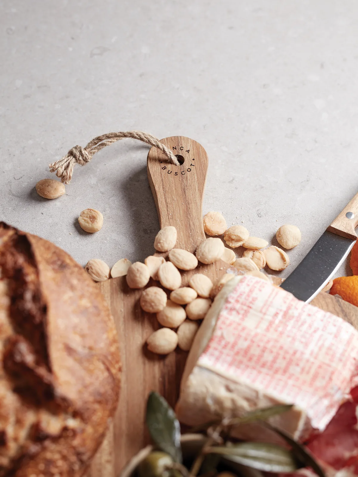 Houten borrelplank met lasergravure logo als eindejaarsgeschenk, met brood, kaas en olijven.