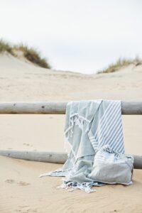 Strandlakens over een houten hek in de duinen bij het strand