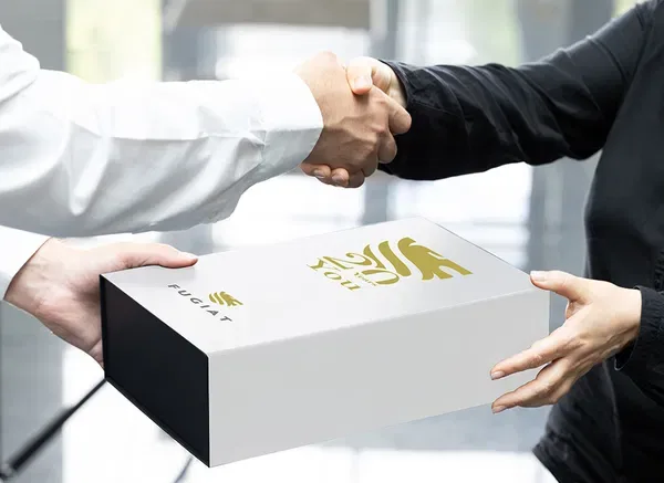 Giftbox met sleeve voorzien van een logo, overhandigd met een handdruk als relatiegeschenk.